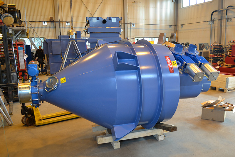 Large blue DISAB industrial pre-separator positioned inside a workshop, designed for integration with vacuum systems and equipped with various output and control options for BigBag, recycling, or continuous discharge.