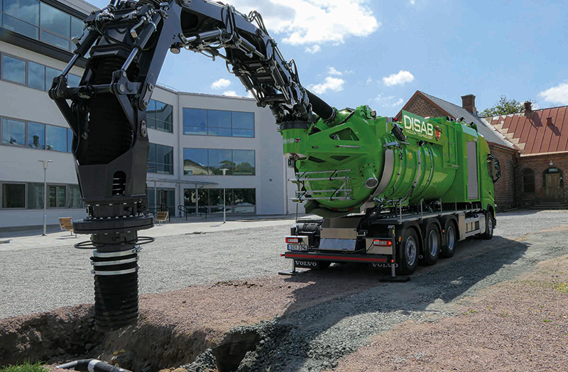 DISAB MultiFLEX vacuum loader positioned on a gravel surface with its articulated hose arm extended and lowered, showcasing its five-section reach and digging capabilities for industrial cleaning and excavation.
