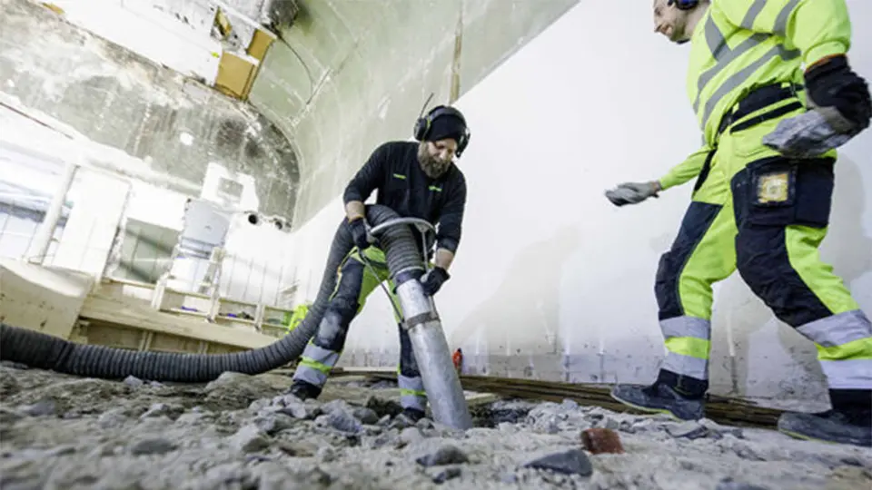 Industriell operatör använder en DISAB vakuumlastare för att avlägsna vått skräp från marken under en tung rengöringsoperation.