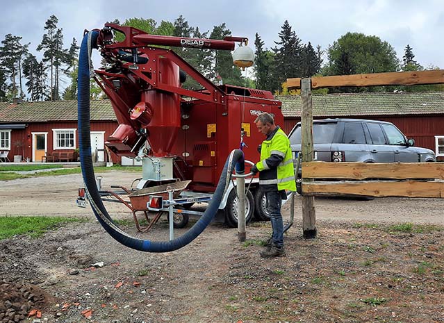 Operator using a TrailerVAC™ SDW-3.5T suction excavator connected to a pickup truck in a rural setting.